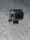 GoPro waterproof action camera in gray housing with display, lens, and helmet mount