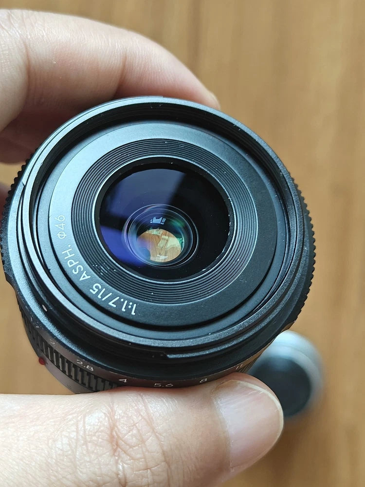Micro Four Thirds camera lens with front glass and focus ring, black
