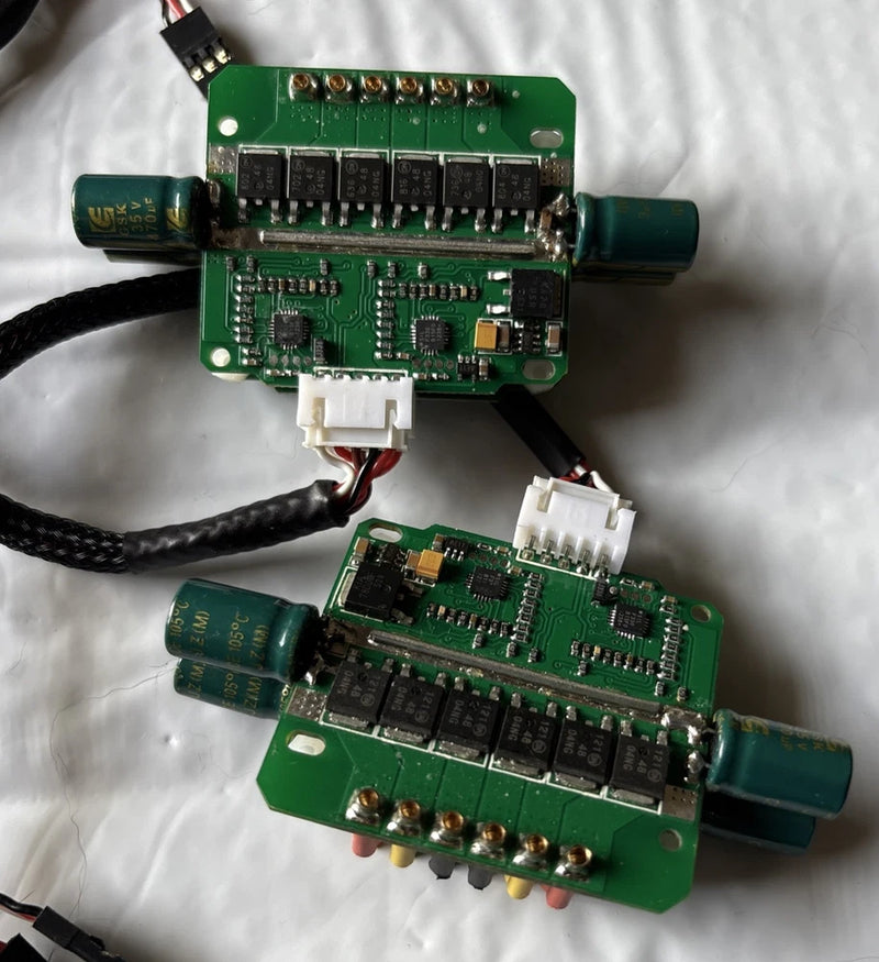 Two brushless RC ESC PCB boards, green circuits with connectors and capacitors