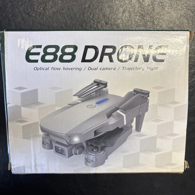 Folding drone with protective case, gray quadcopter shown on product box