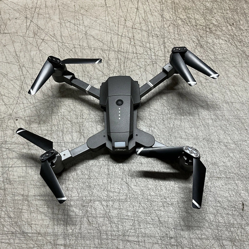 Dark gray quadcopter drone with four propeller arms and foldable landing gear
