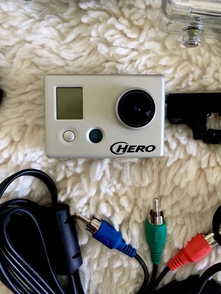 GoPro action camera with front display, lens, and connected cables
