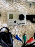 GoPro action camera with front display, lens, and connected cables