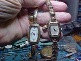 Pair of silver-tone ladies analog wristwatches with metal bracelet, close-up