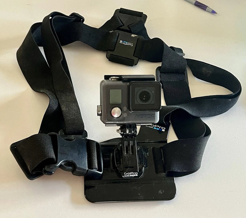 GoPro waterproof action camera with chest mount straps, in clear housing