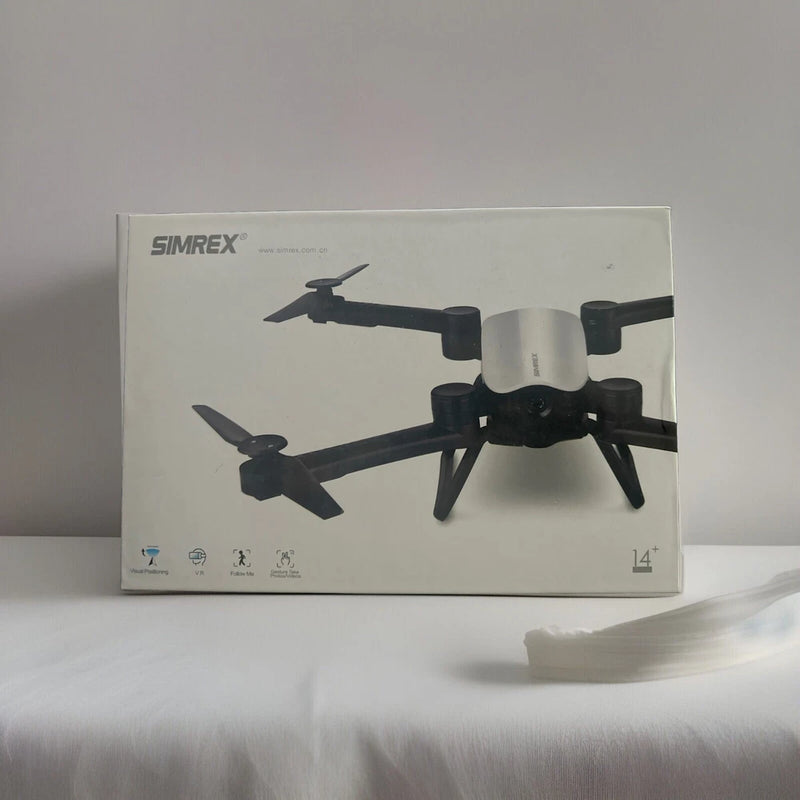 Foldable quadcopter RC drone shown on product box with controller and propellers