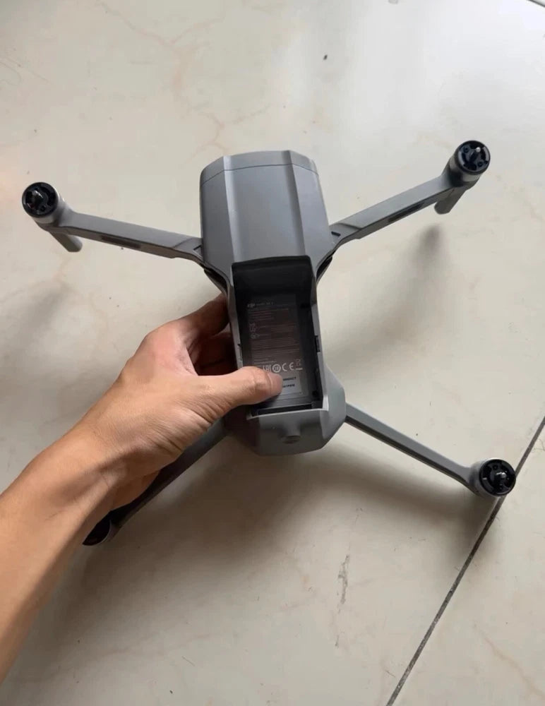 Folding grey drone with four propellers, handheld front view