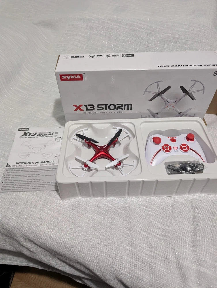 Red, black and white quadcopter drone and remote control in retail box set