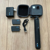 Waterproof action camera with handheld grip, protective case, charger, and USB cable