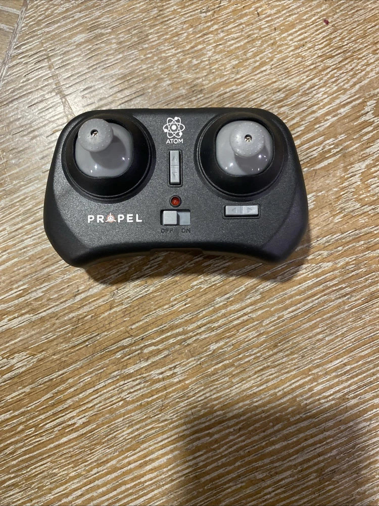 Black drone remote controller with two joysticks, Atom logo, and Propel text