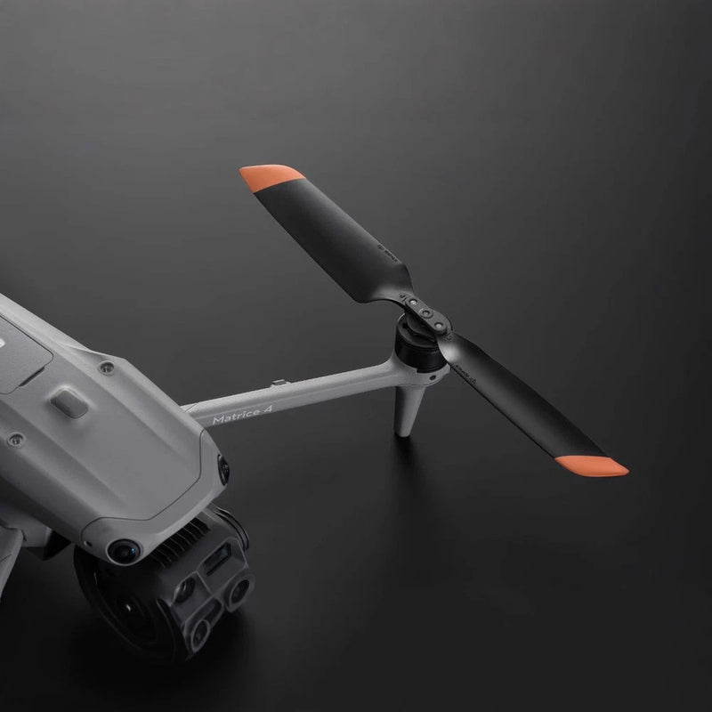 Low-noise drone propeller with orange tips attached to a gray drone