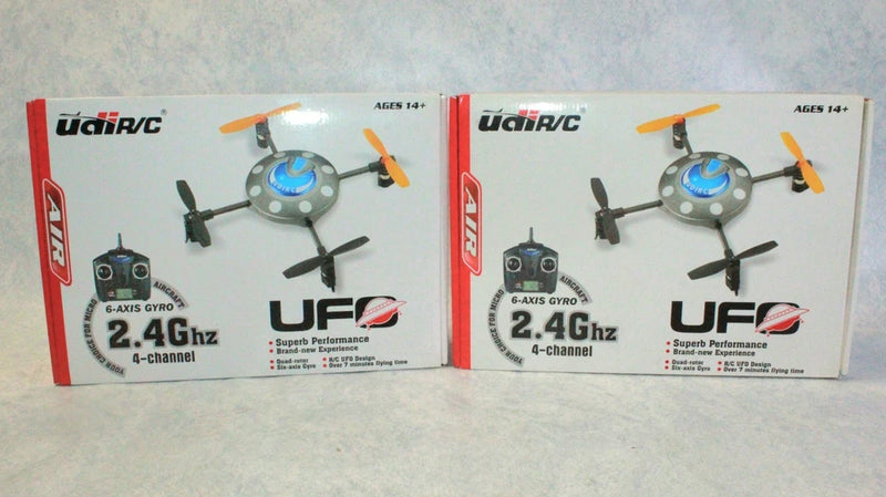 Two UDI U-R/C UFO 2.4GHz 4-channel quadcopter drone models in retail boxes