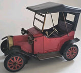 Battery-powered maroon open-top toy car with black roof, red-spoked wheels and steering area