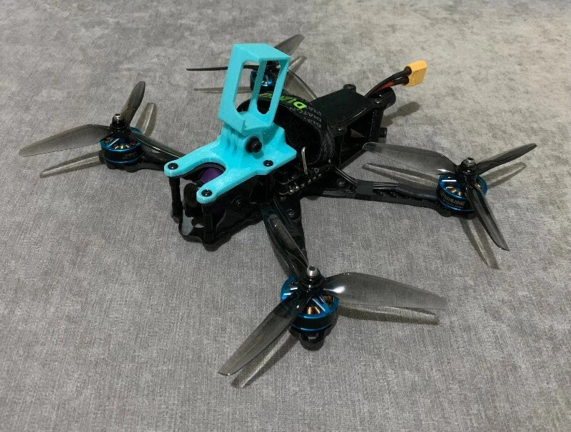 Turquoise 3D-printed GoPro-style mount on FPV drone frame