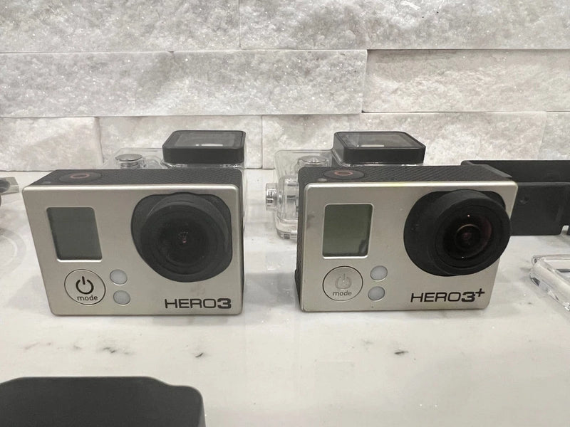 GoPro HERO3 and HERO3+ action camera bundle, two silver cameras with black lenses