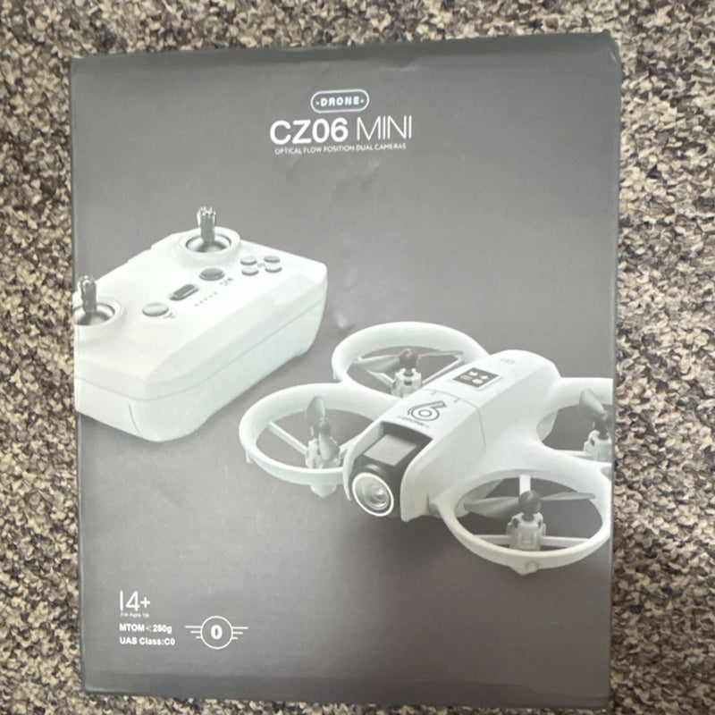 White mini quadcopter drone with remote controller on product box