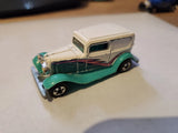 Die-cast toy delivery woodie truck with green body and cream top, detailed grille and wheels