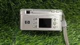 Silver HP compact digital camera front with LCD screen and control buttons