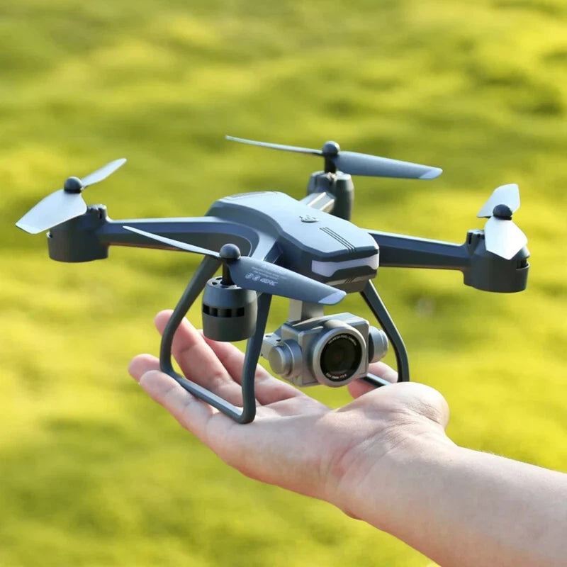Blue and gray quadcopter drone with front camera, held in a hand