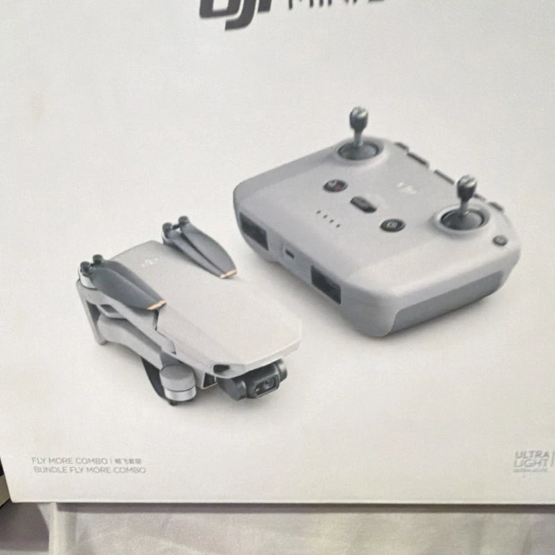Camera drone and remote controller, light gray with black propellers