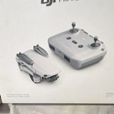 Camera drone and remote controller, light gray with black propellers
