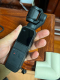 Handheld gimbal stabilizer camera with touchscreen on dark body, held by a hand