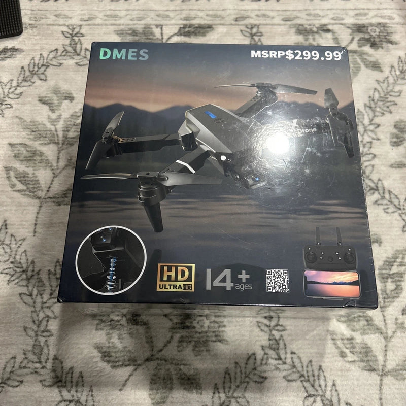 Foldable quadcopter drone with dual cameras, shown on retail box, DMES brand
