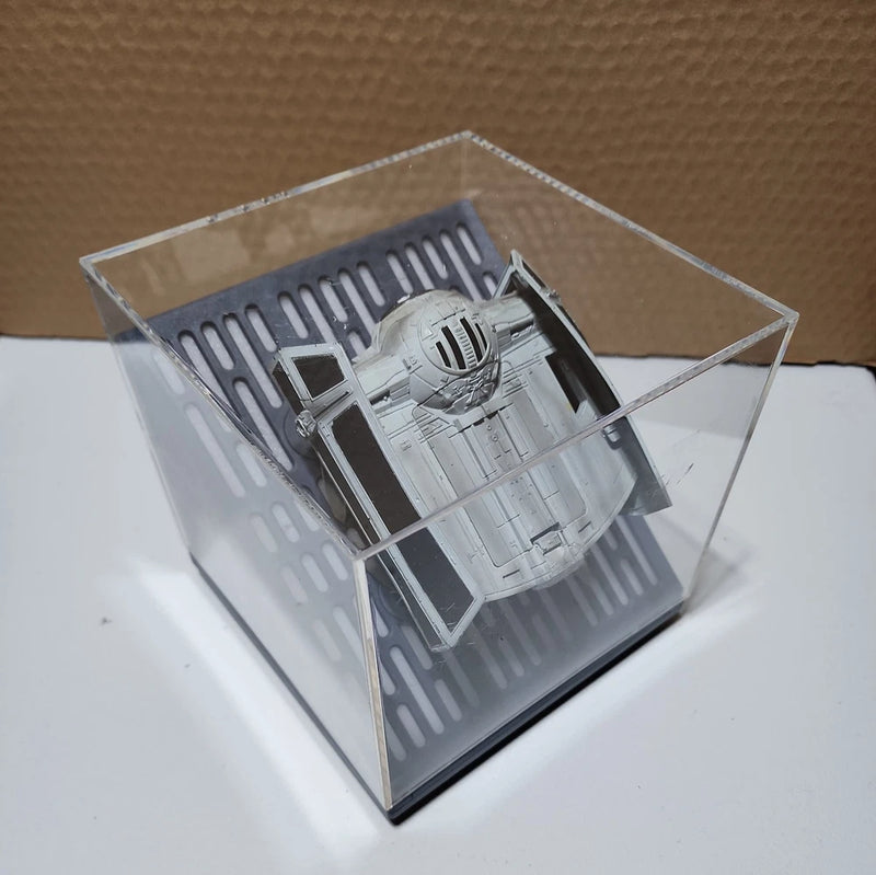 Gray and black RC battling drone in clear display case, exposed chassis detail