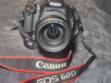 Canon DSLR camera with attached lens and Canon EOS 60D neck strap