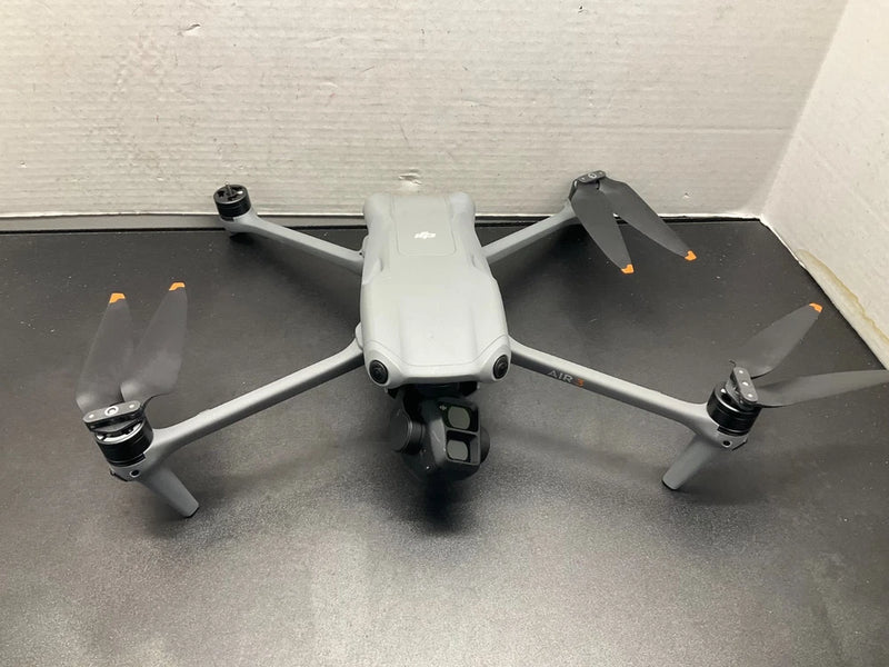 DJI white quadcopter drone with four propellers and camera housing, landing legs visible
