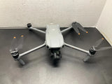 DJI white quadcopter drone with four propellers and camera housing, landing legs visible