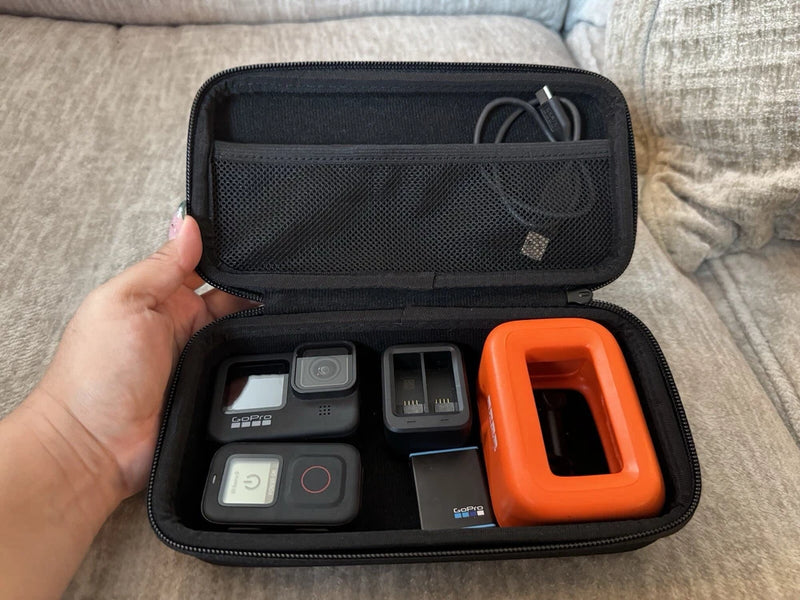Action camera kit case with GoPro HERO9 Black camera, mounts, and orange housing