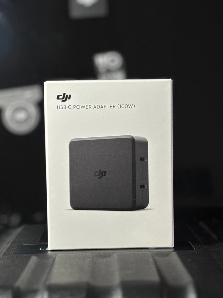 DJI USB-C power adapter (100W) in retail box, showing dark adapter