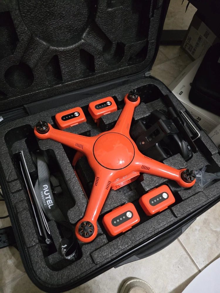 Orange quadcopter drone in a black hard case with accessories