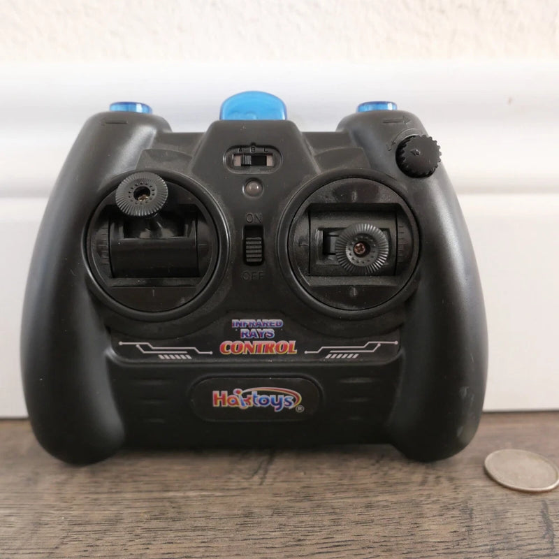 Black handheld RC remote control with two joystick grips and central button panel