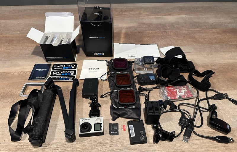 Silver action camera kit with mounts, battery, remote, and protective cases accessories