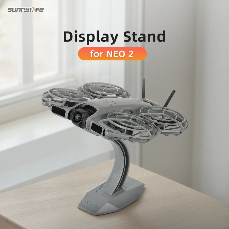 Gray drone display stand mount bracket with curved arm and flat base holding a drone
