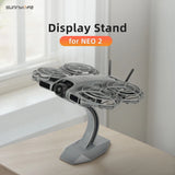 Gray drone display stand mount bracket with curved arm and flat base holding a drone
