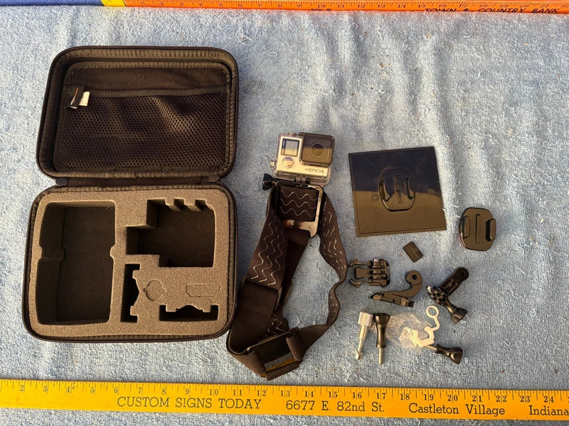 GoPro action camera accessories kit with open case, mounts, harness, and spare parts
