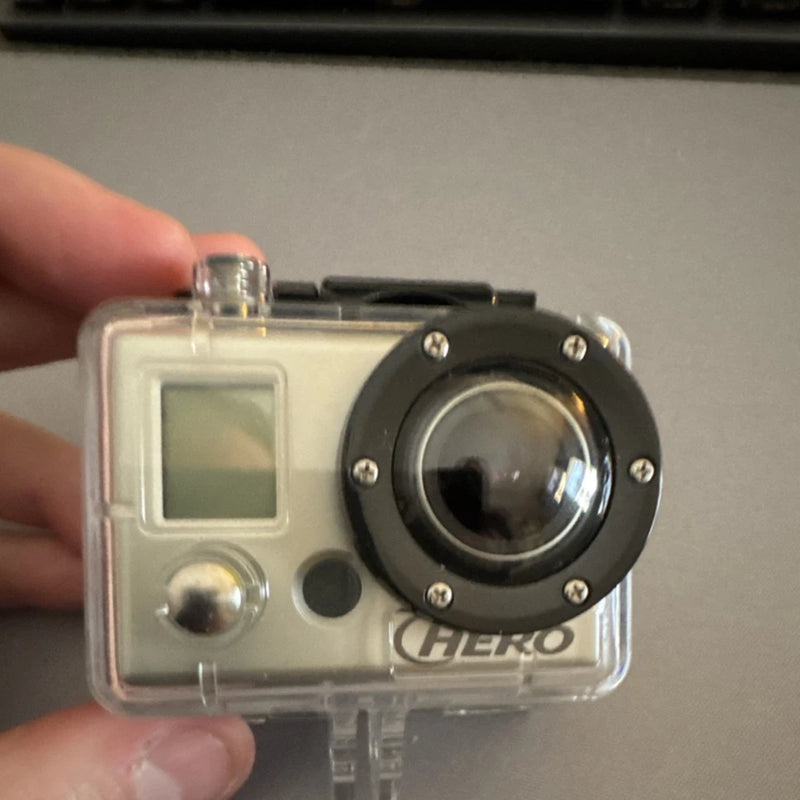 Waterproof action camera in clear housing with front lens and HERO badge
