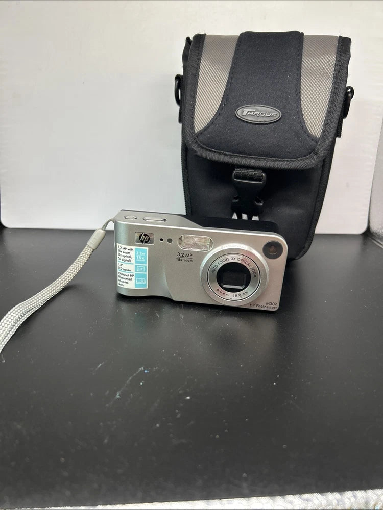 Silver digital camera with front lens and HP label, in black protective carrying case