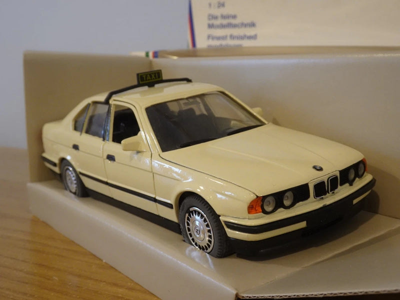 Beige BMW taxi model car with front grille and headlights, 1:24 scale