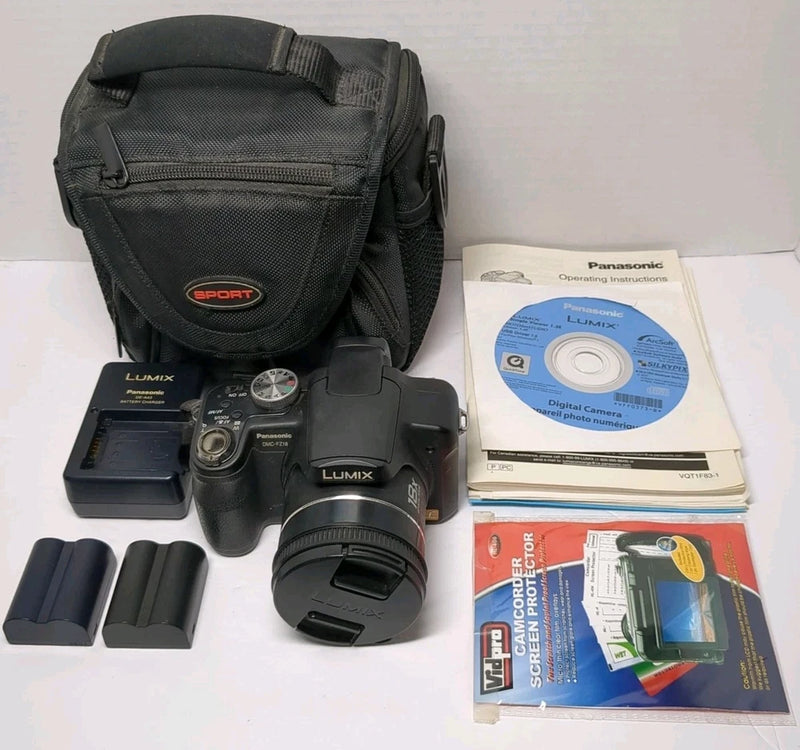 Digital camera kit with black case, spare batteries, charger, manuals, screen protectors.