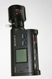 Black Sony action camera with front lens, LCD screen, and side buttons