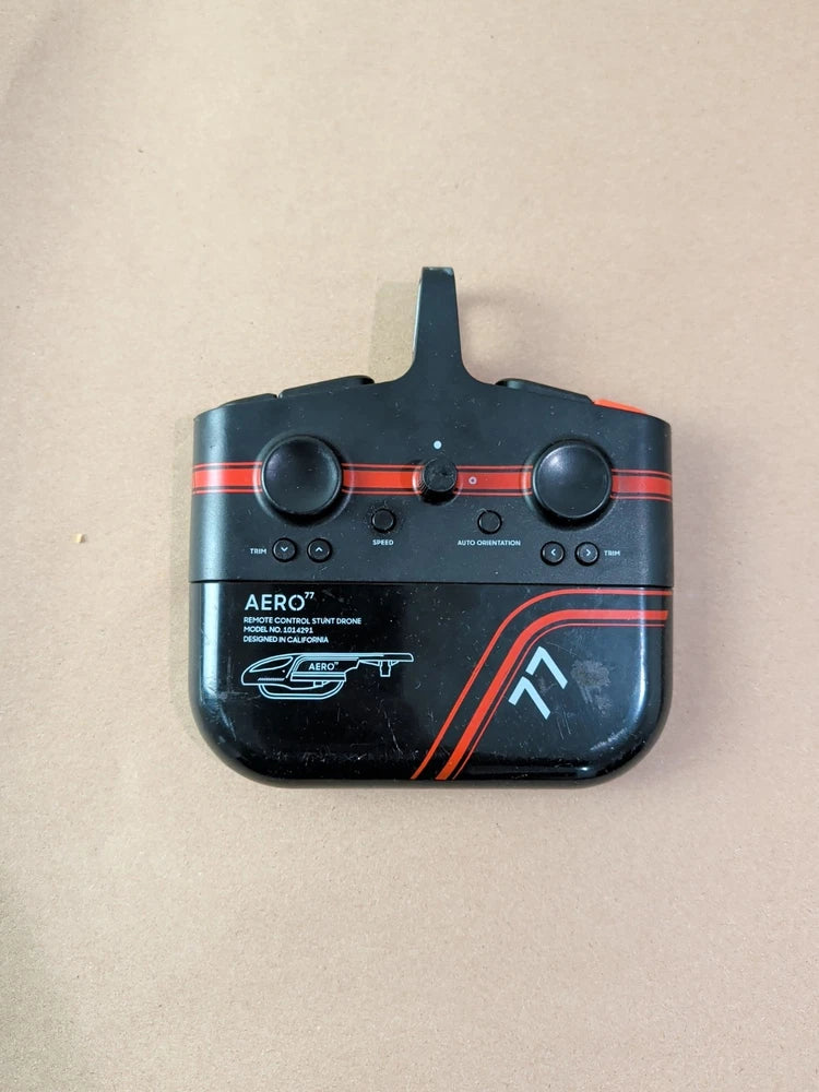 Black ergonomic remote controller with two thumb grips, buttons, and top antenna