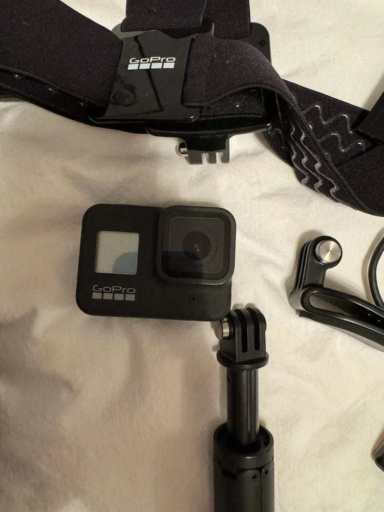 GoPro action camera with front screen and mount bracket, plus handle accessory