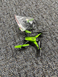 Green toy drone with four propellers, folded legs and black landing gear