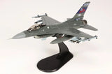 Gray F-16C fighter jet scale model on black display stand, detailed cockpit and markings