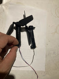 Black drone propeller motor mount assembly with two folded propellers and wiring