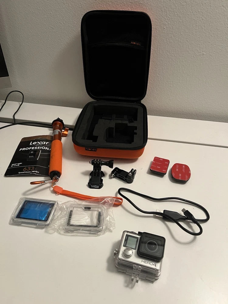GoPro action camera kit with orange grip, mounts, waterproof case, and memory card